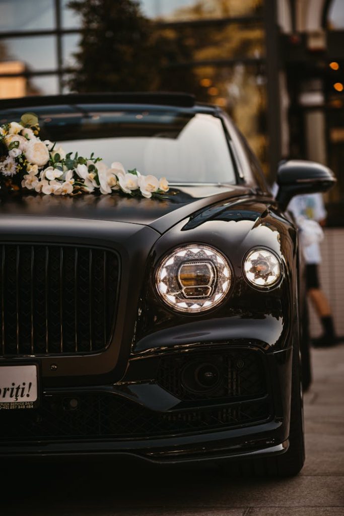 Elegant black luxury car adorned with flowers, parked outdoors in Arad, Romania.